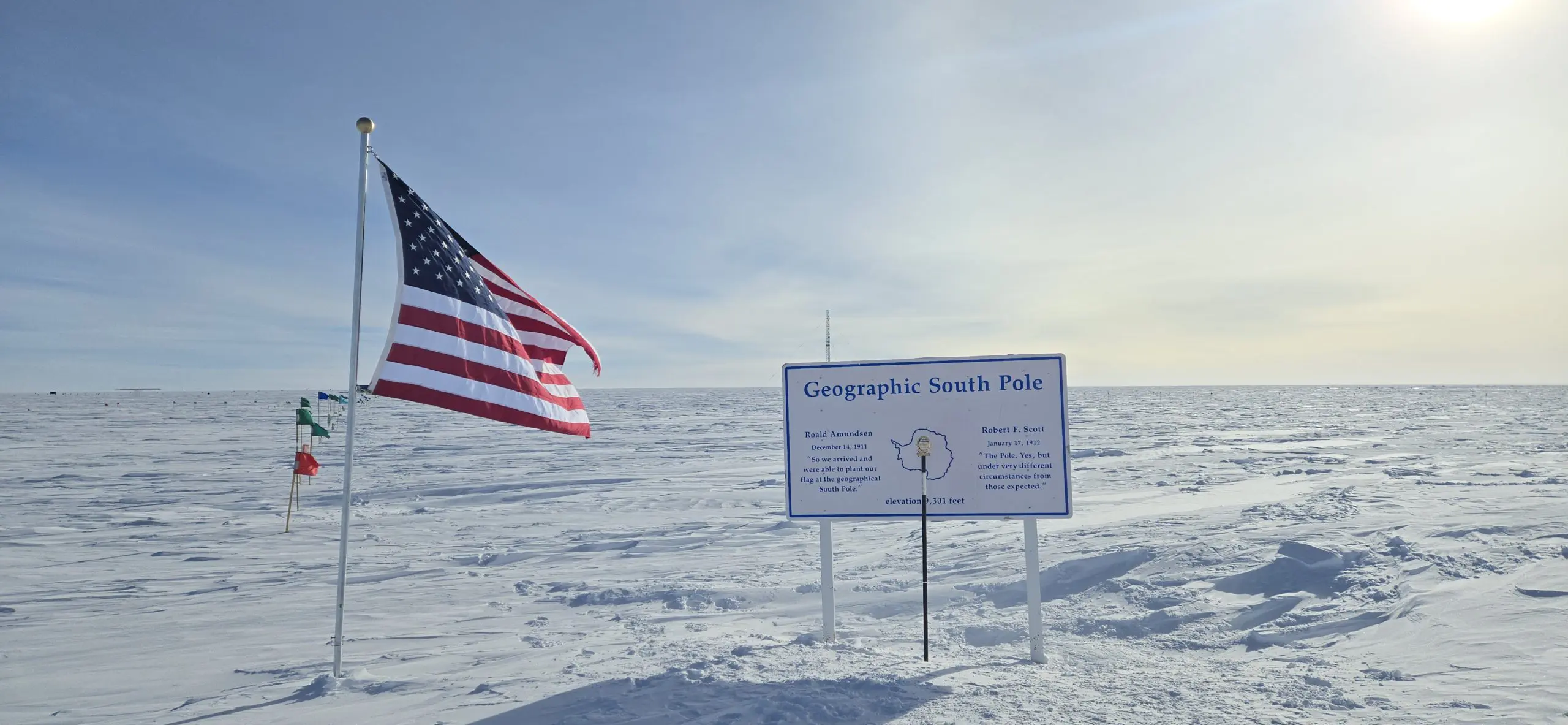 Geographic South Pole in Antarctica with an American flag waving in the wind